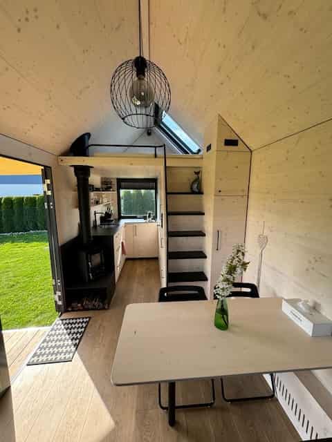 Interior of off-grid tiny house Hutka — stove, stairs, kitchenette